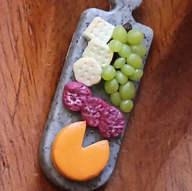 charcuterie board design on a wooden bowl against a dark background