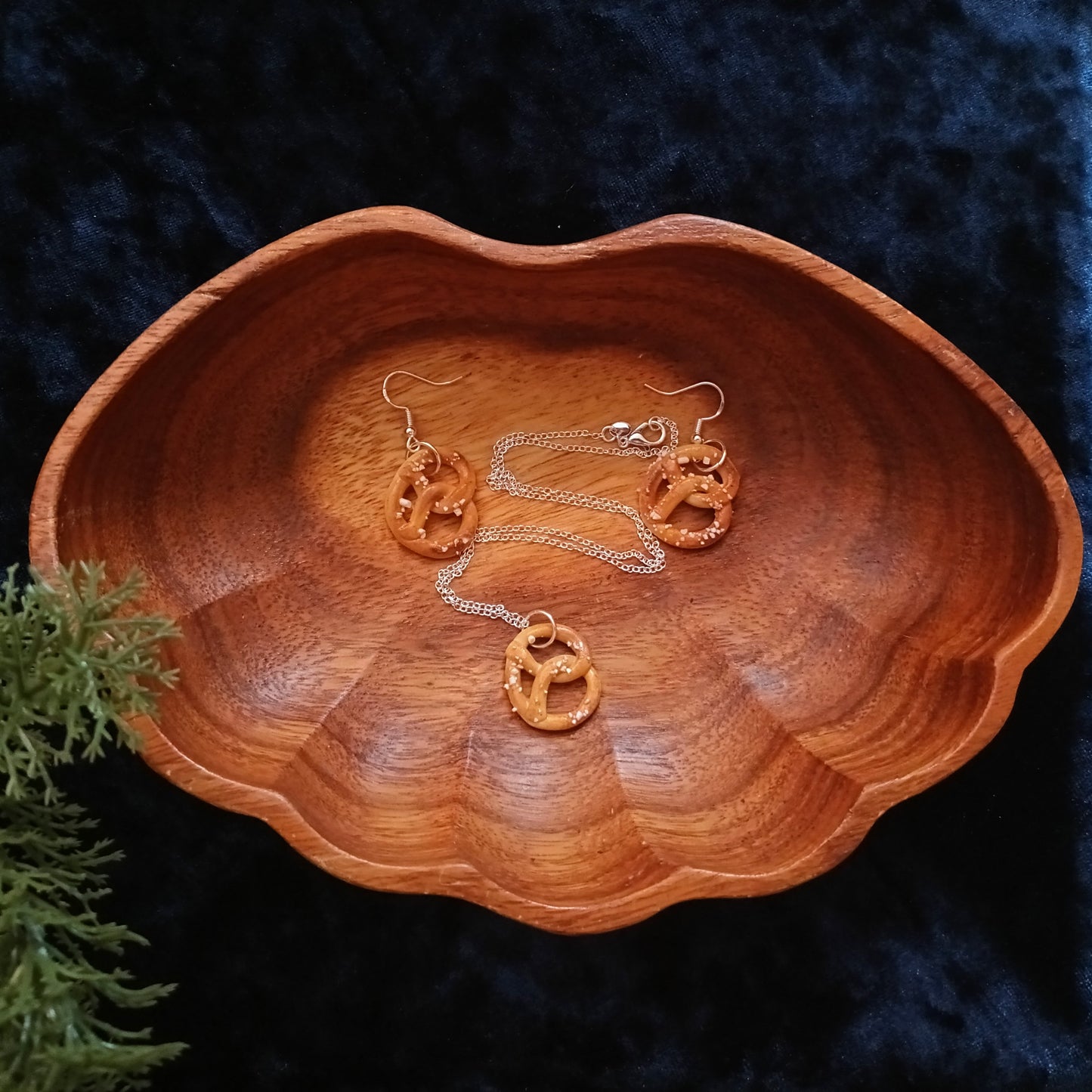 Wooden dish with gold jewelry on a dark textured background