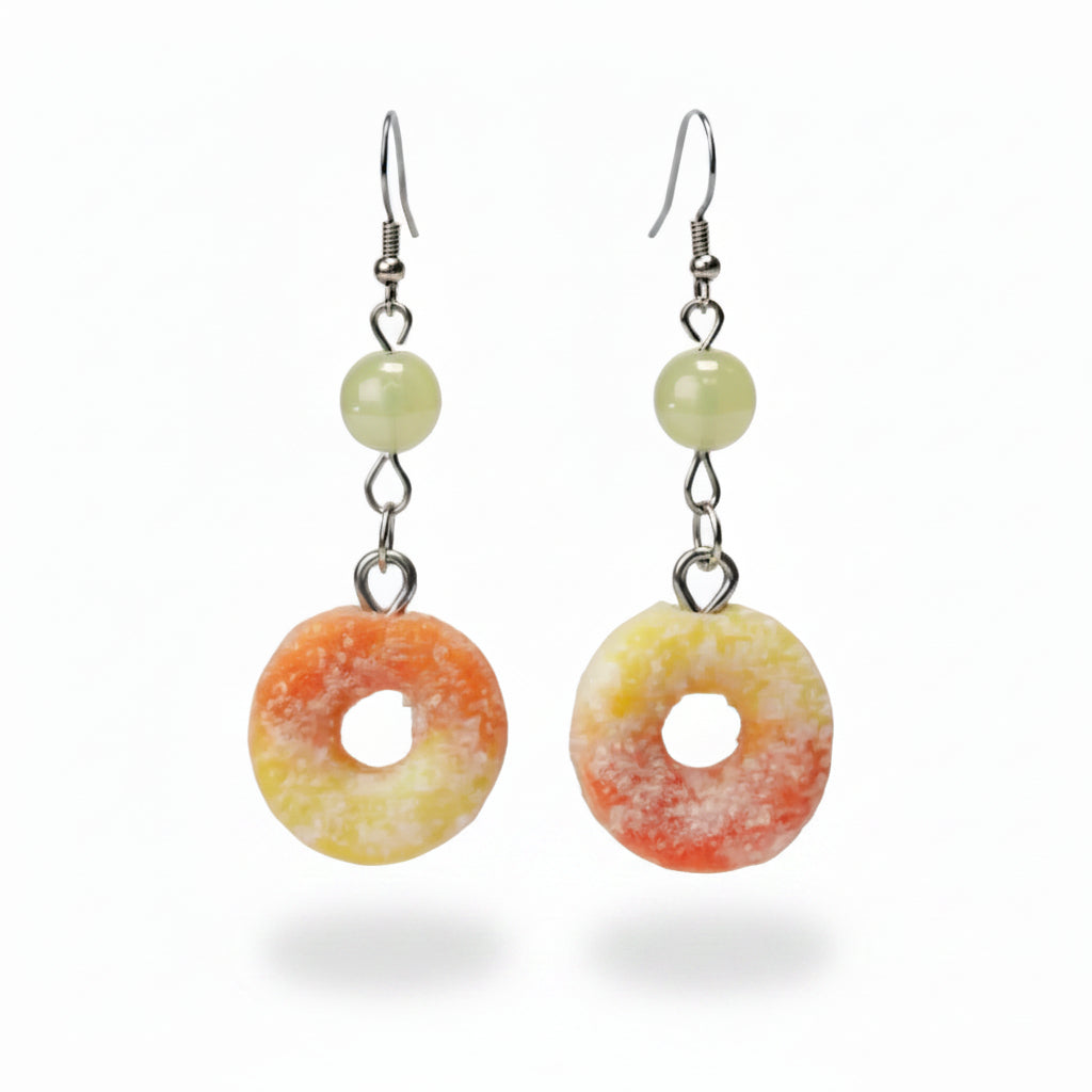 Donut-shaped earrings with yellow pearly glass beeds on a beige background