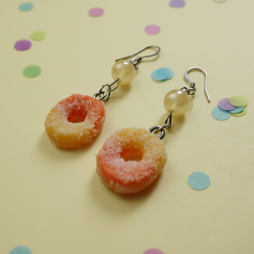 peach ring shaped earrings on a plain background