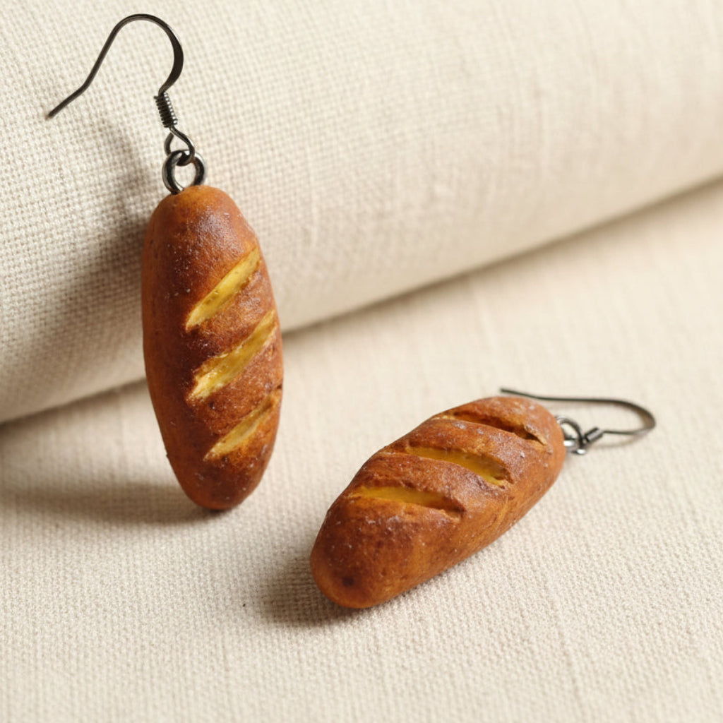 Loaf-shaped earrings on a beige fabric