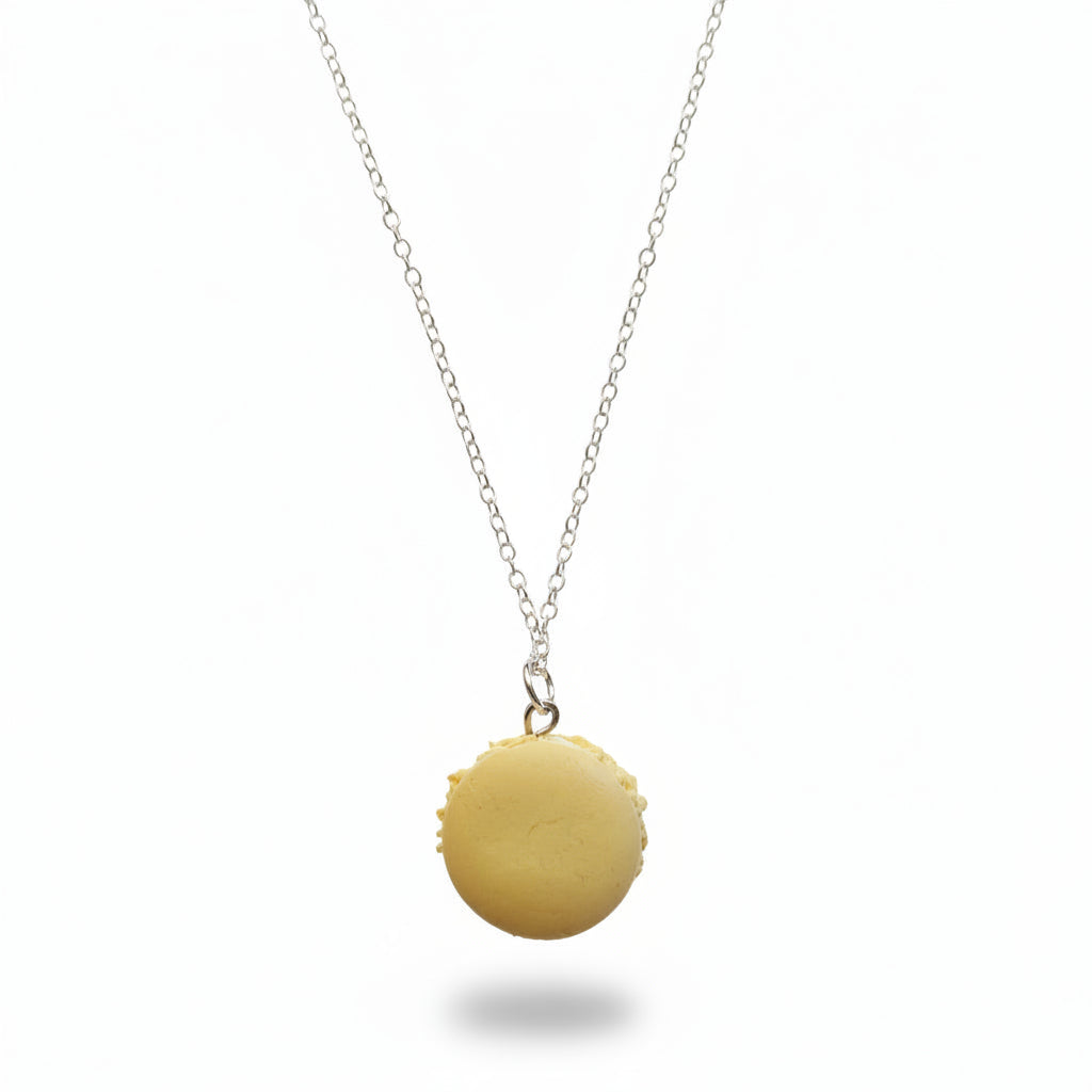 Yellow macaron-shaped pendant on a silver chain against a plain background