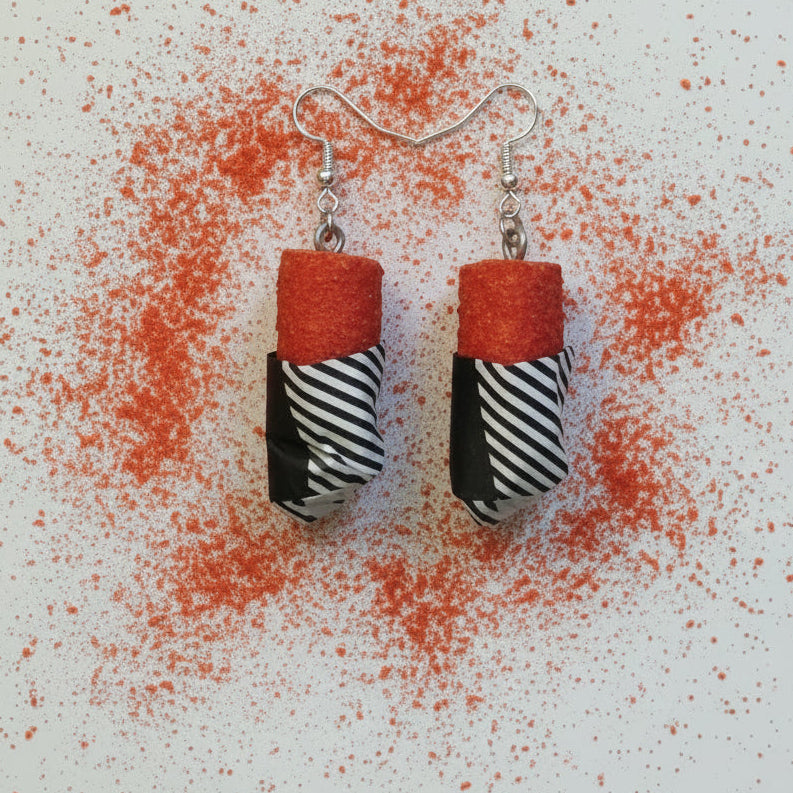 Earrings with red top and black and white striped bottom on a light gray background