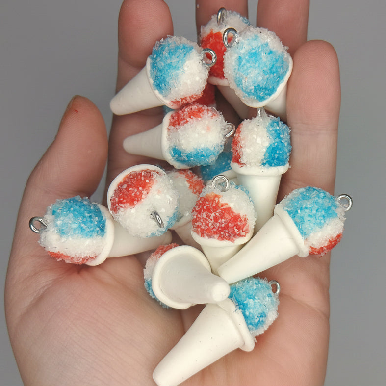 Hand holding small decorative items resembling golf tees with red, white, and blue colors.