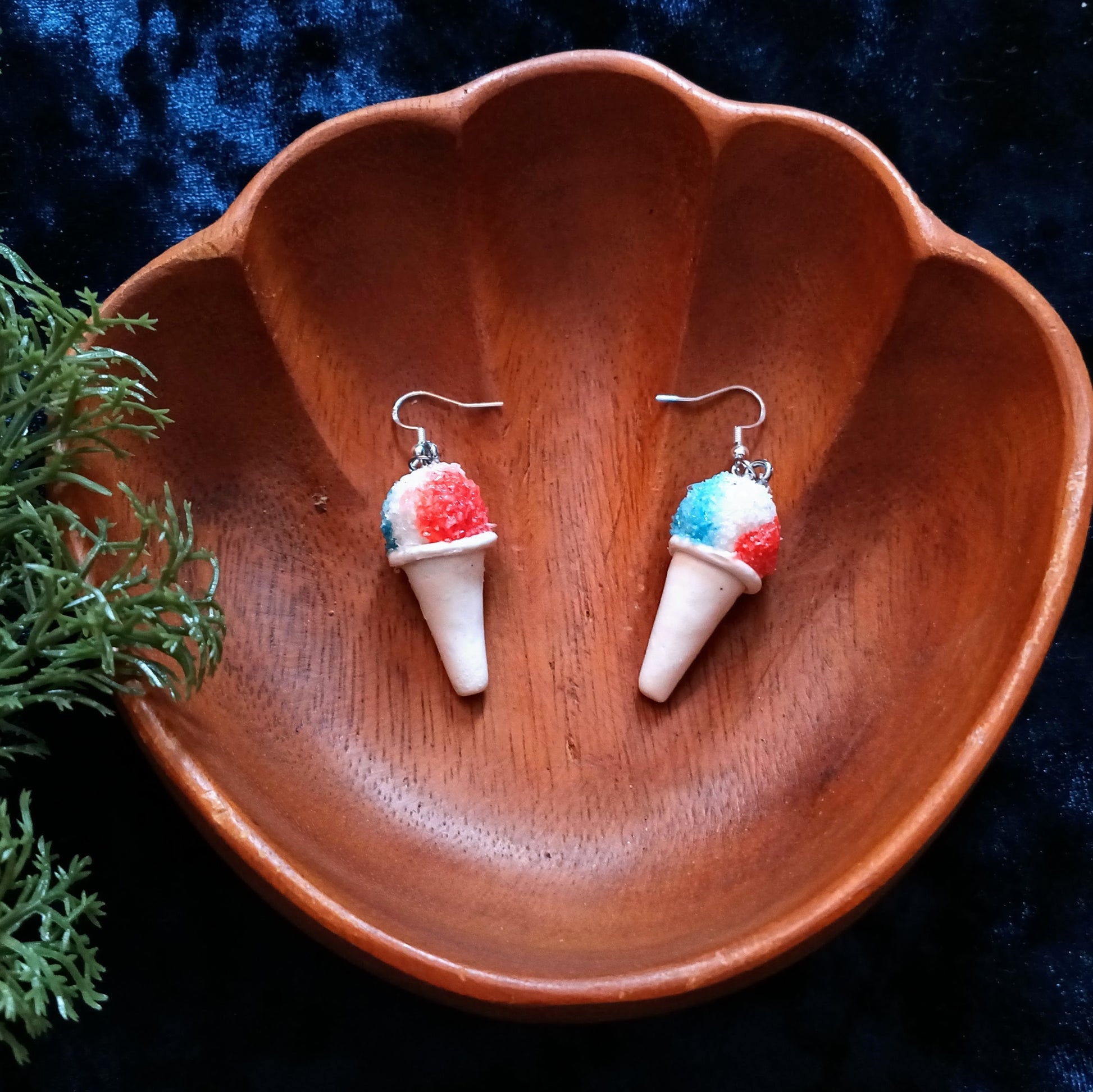 Ice cream cone earrings on a wooden dish with a dark background