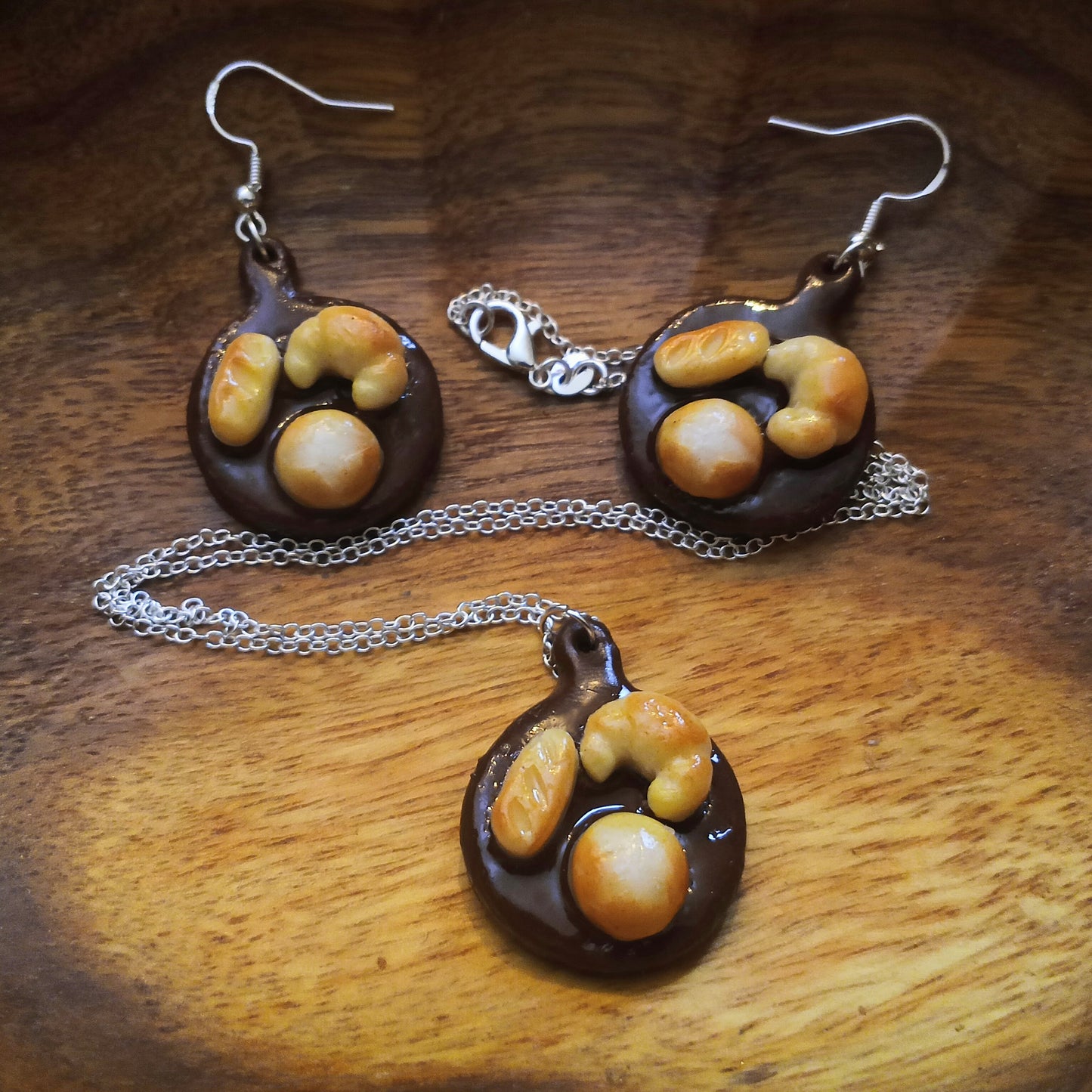 Jewelry set with pendant and earrings on a wooden surface