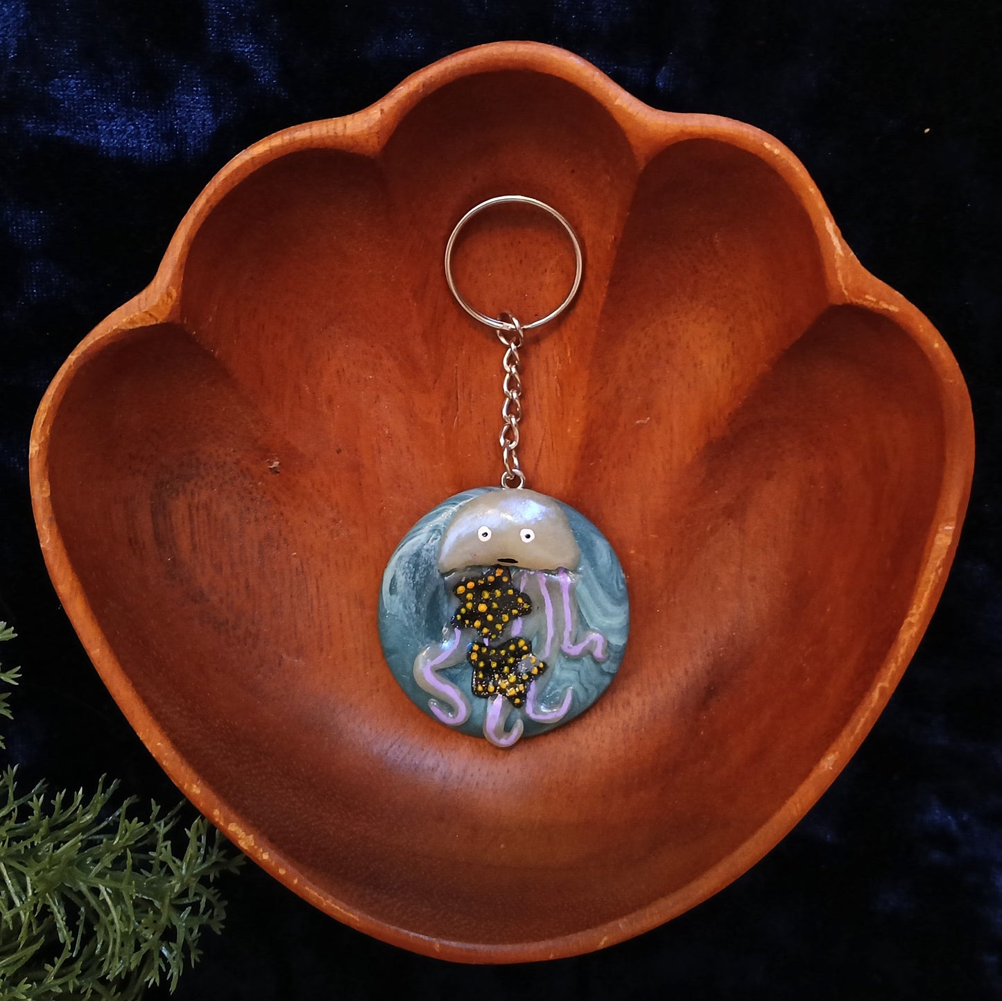Jellyfish-themed keychain in a wooden bowl with a dark background