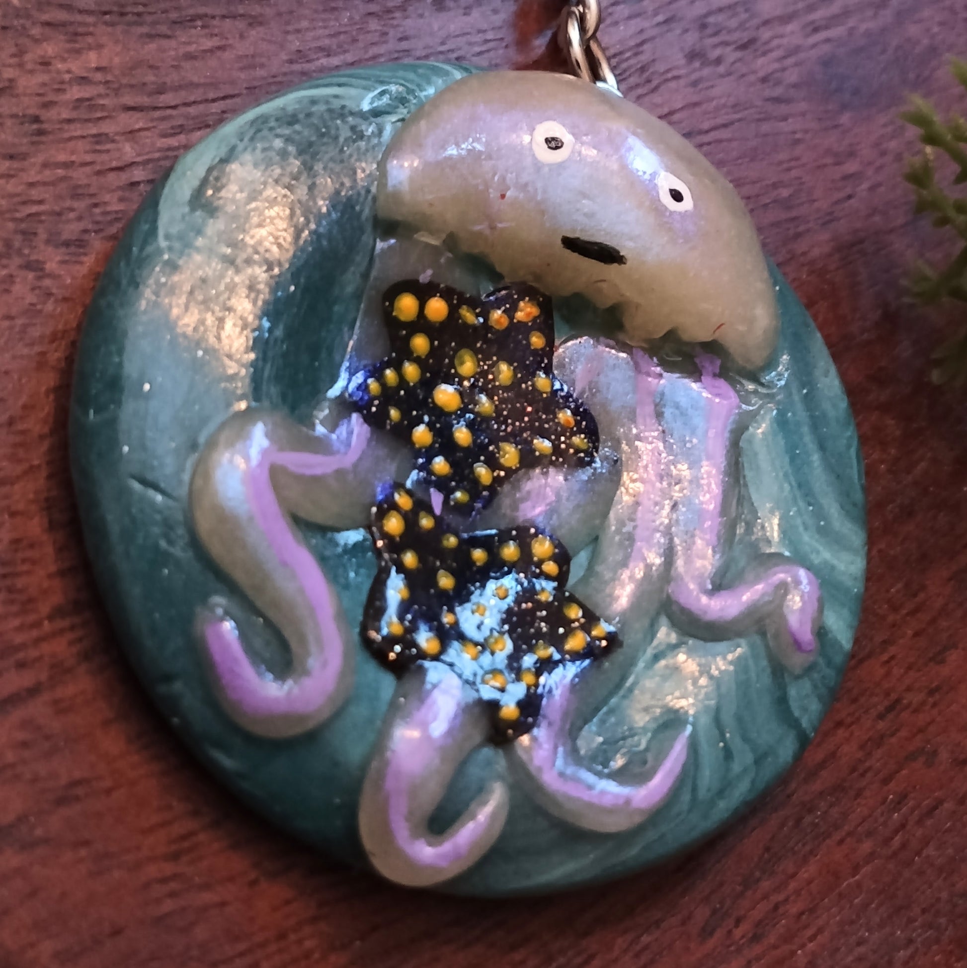Decorative keychain with sea-themed design on a wooden surface