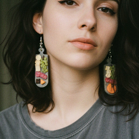 model wearing a pair of earrings with food-themed design 