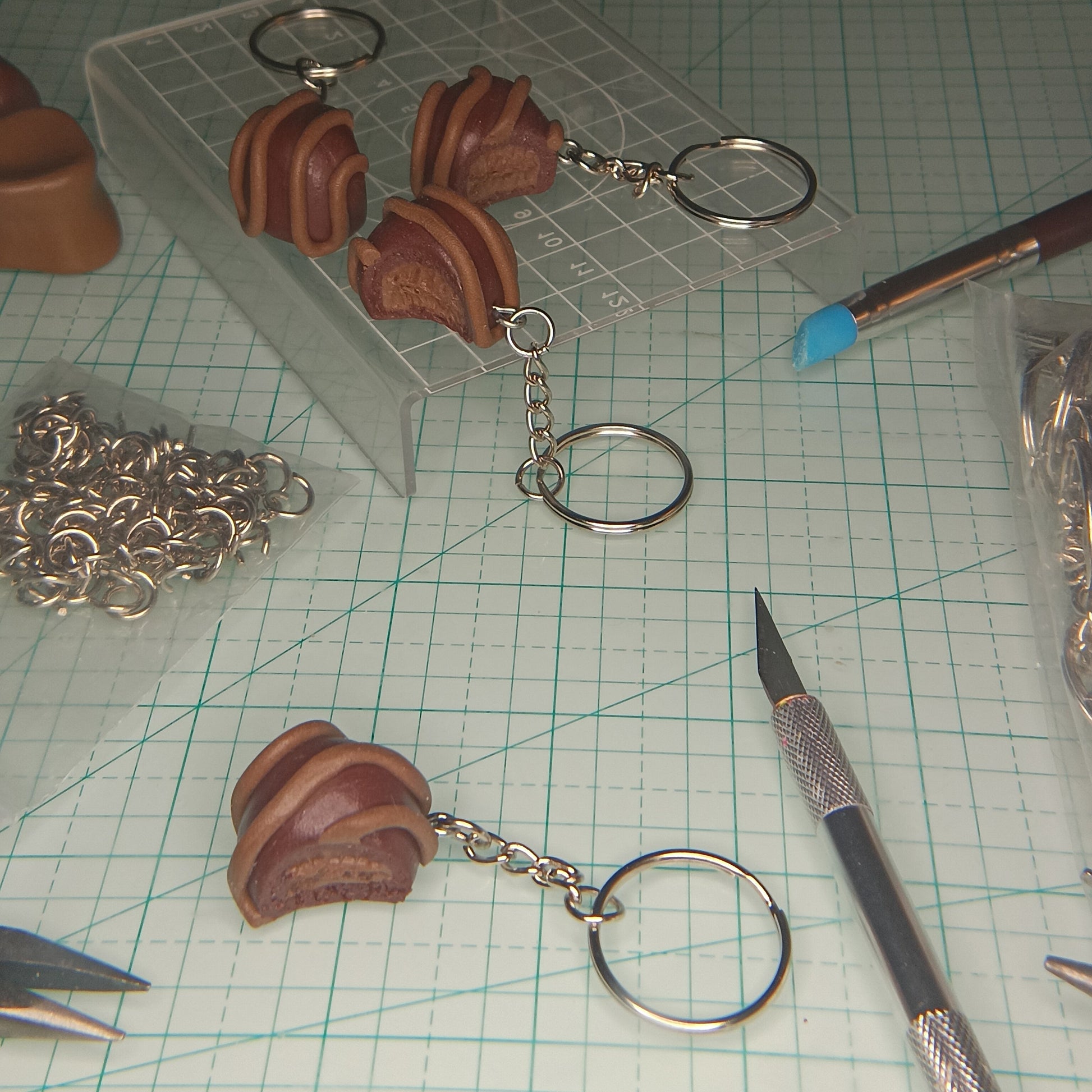 Brown keychain items on a cutting mat with tools and materials.