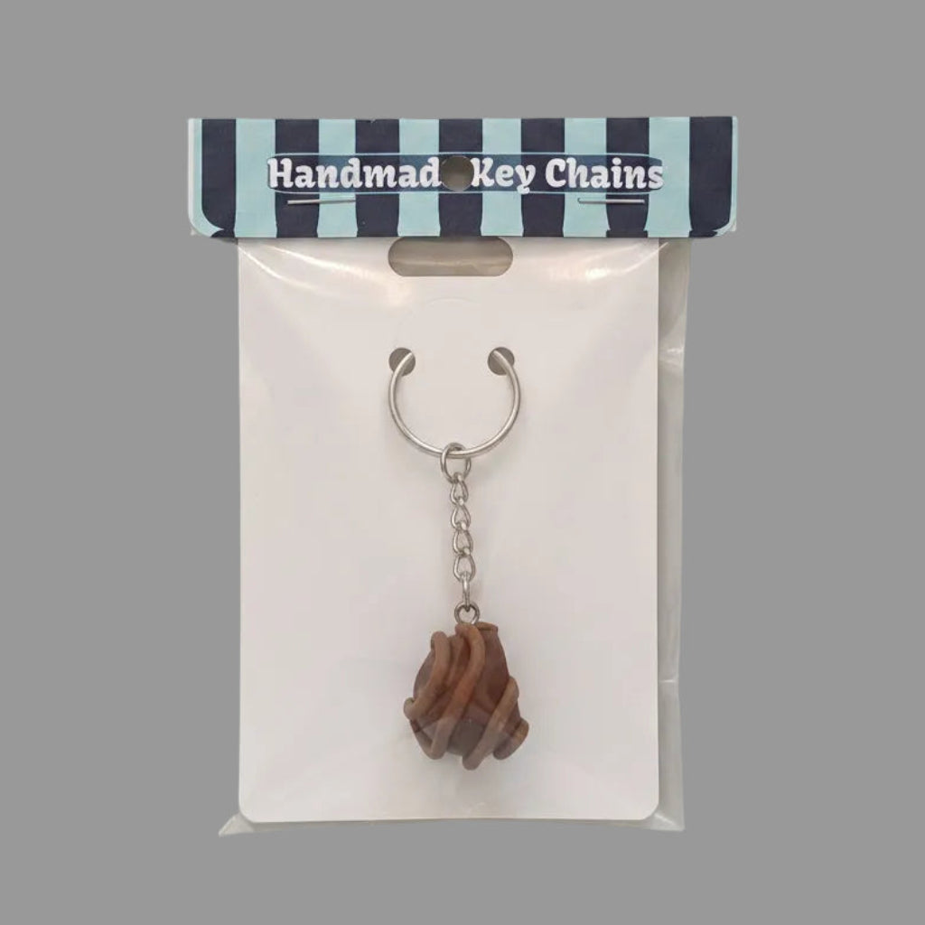 Handmade keychain in packaging on a gray background