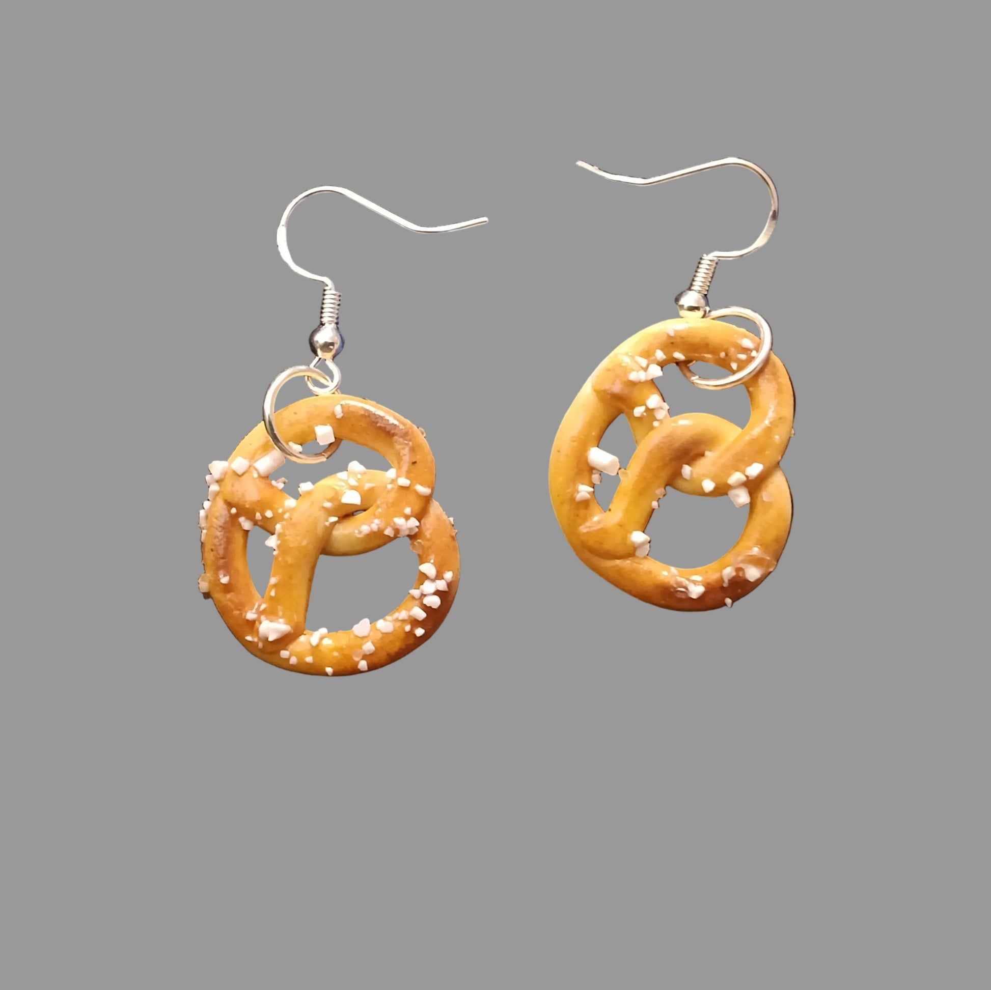 Pretzel-shaped earrings on a gray background