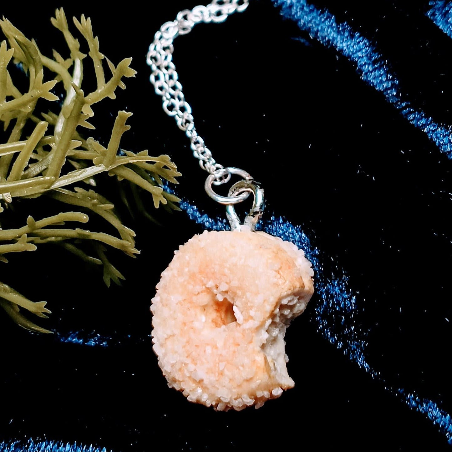 sugar donut necklace on dark background