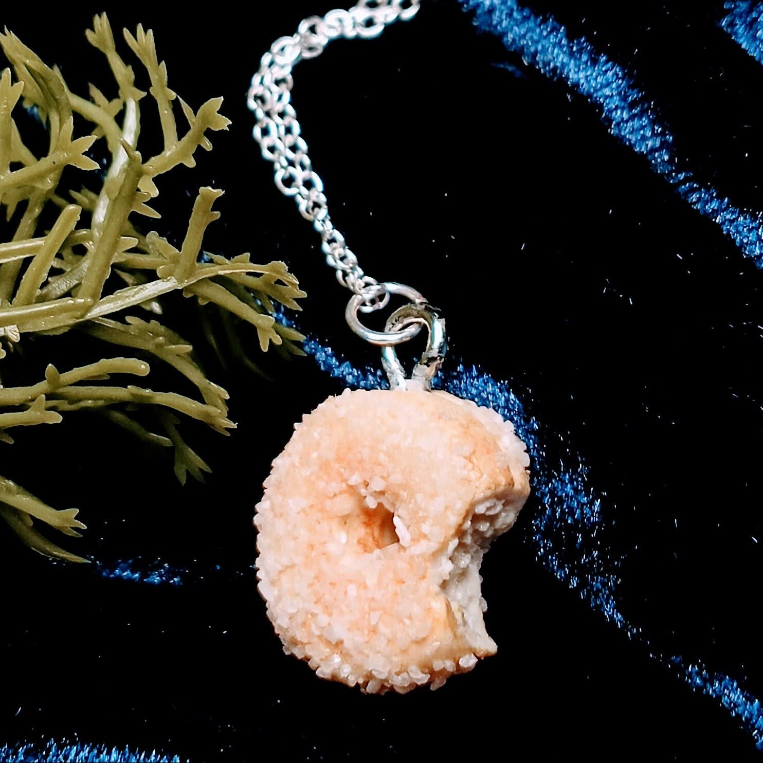 sugar donut necklace on dark background