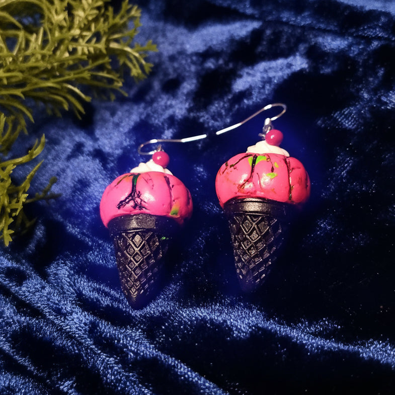 Ice cream cone earrings on a blue textured fabric background