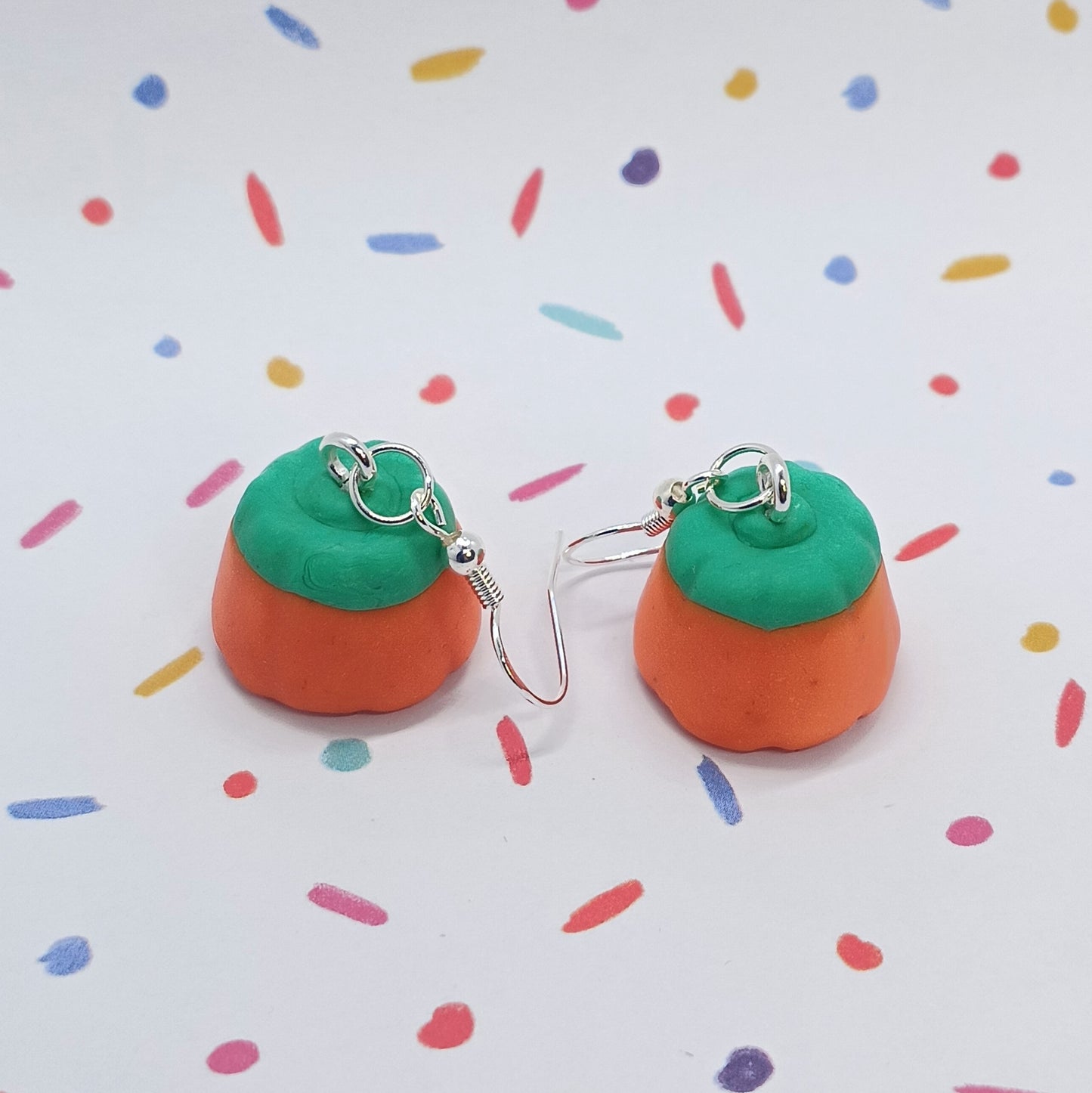 pumpkin candy corn earrings on confetti background