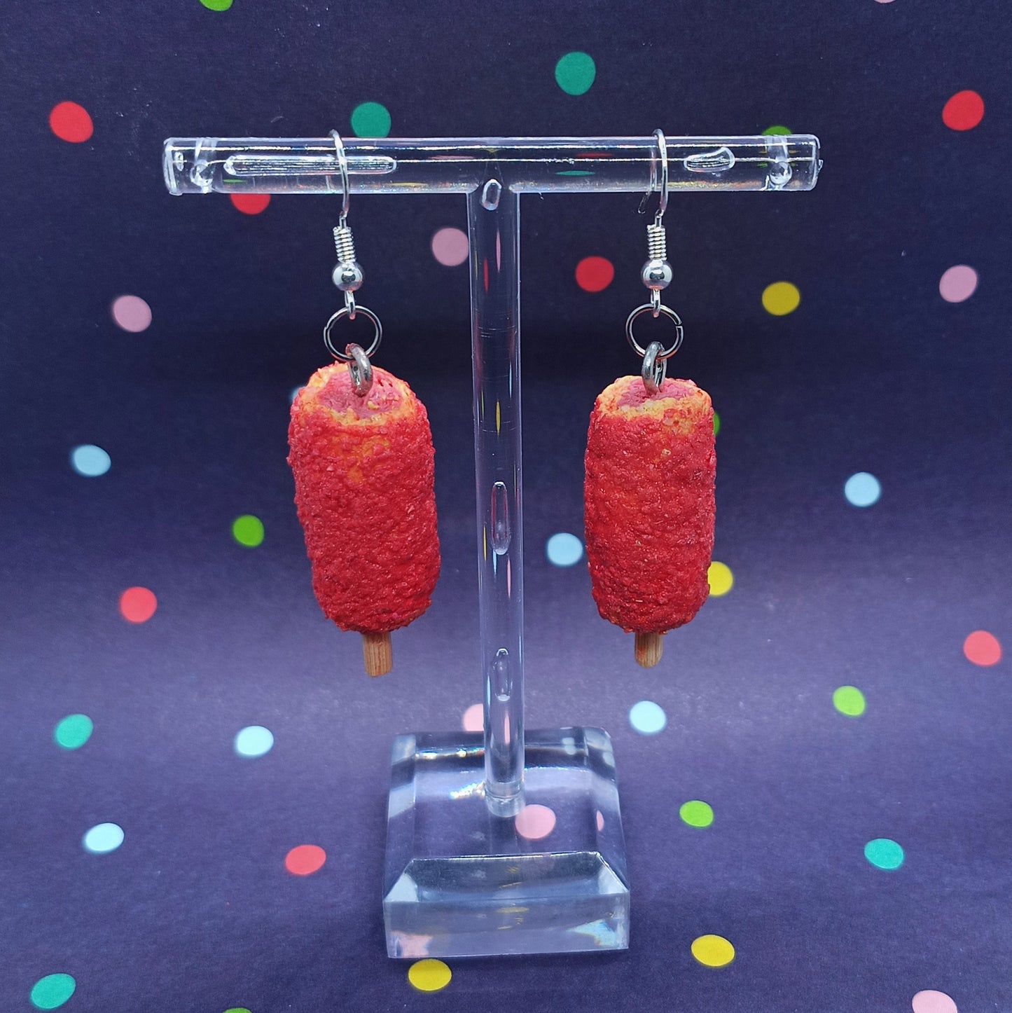 Korean Corn Dog earrings on clear stand and polka dot background