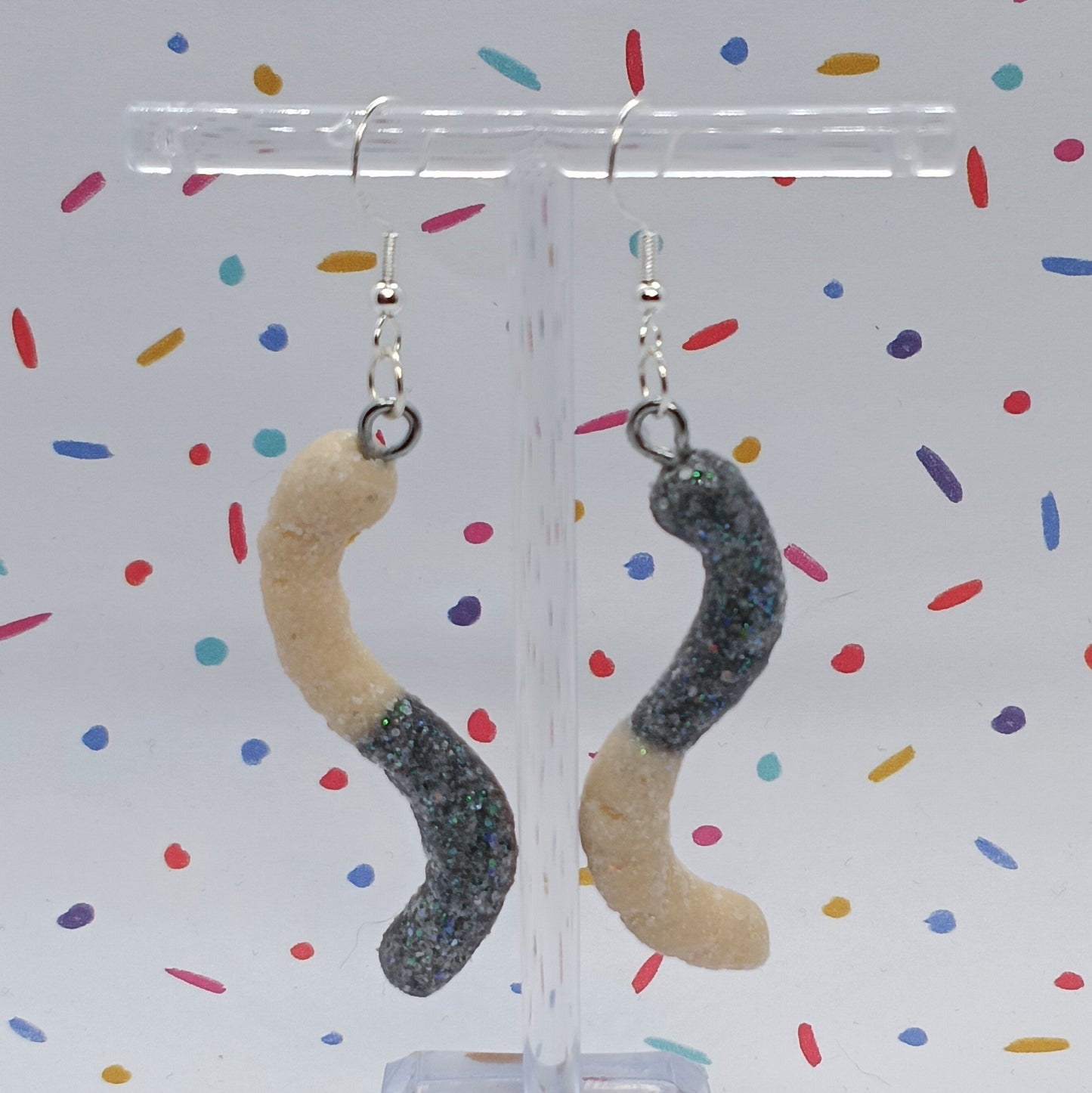 sour warm earrings dangling from clear stand