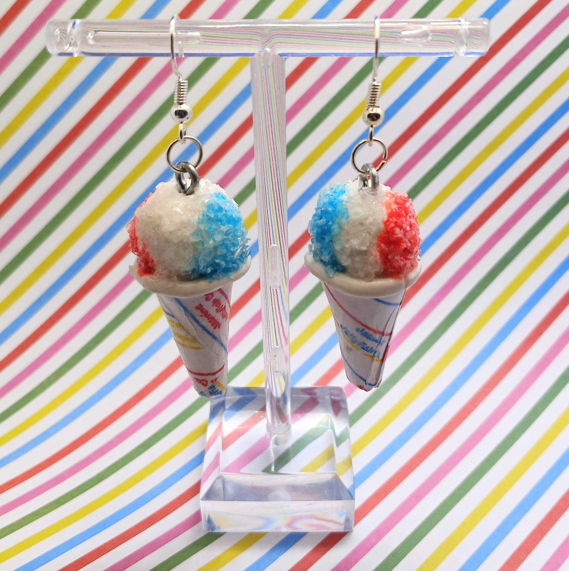Snow Cone Earrings hanging on acrylic stand with striped background