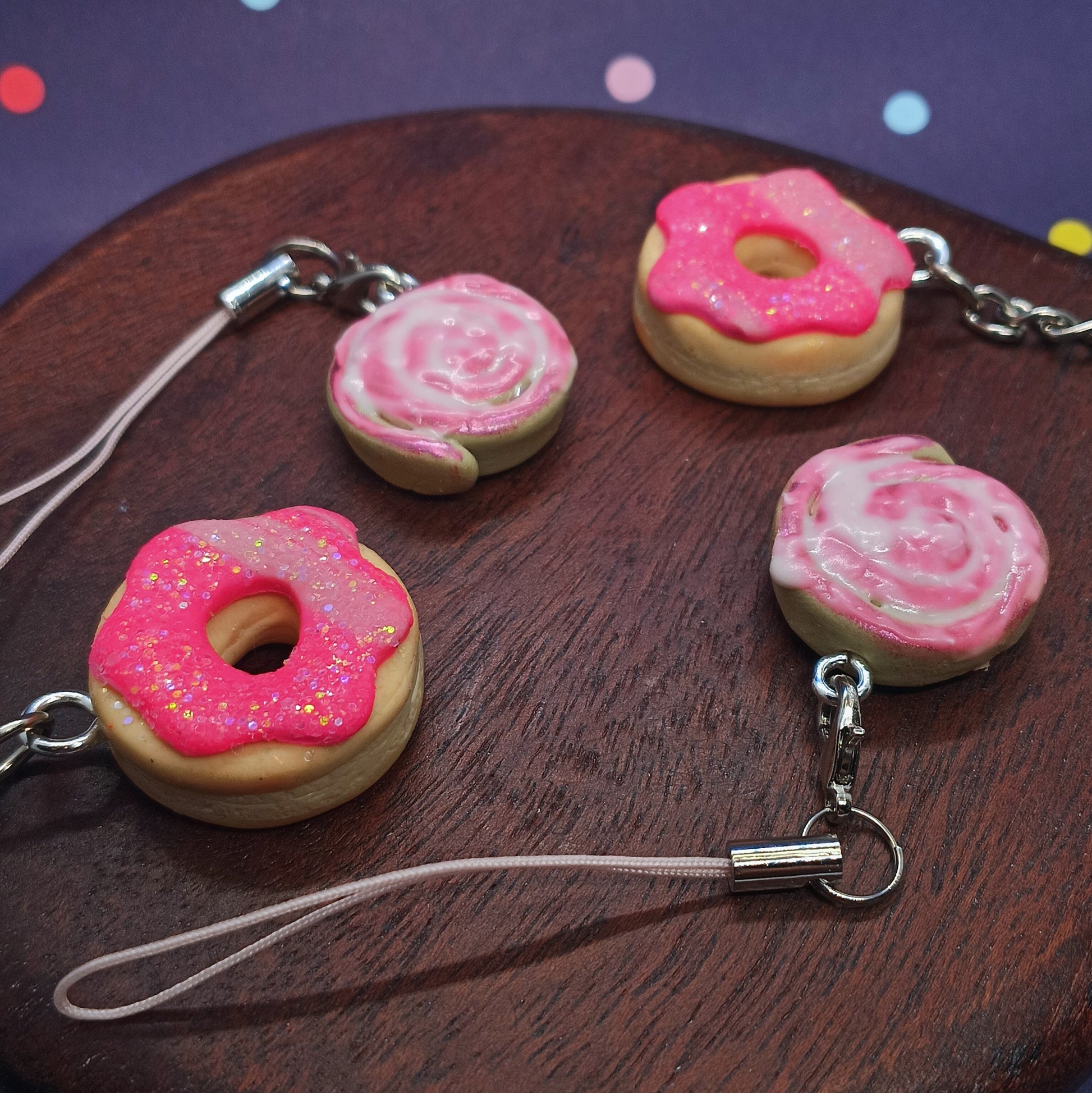 Donut and cinnamon roll charms on a wooden board 