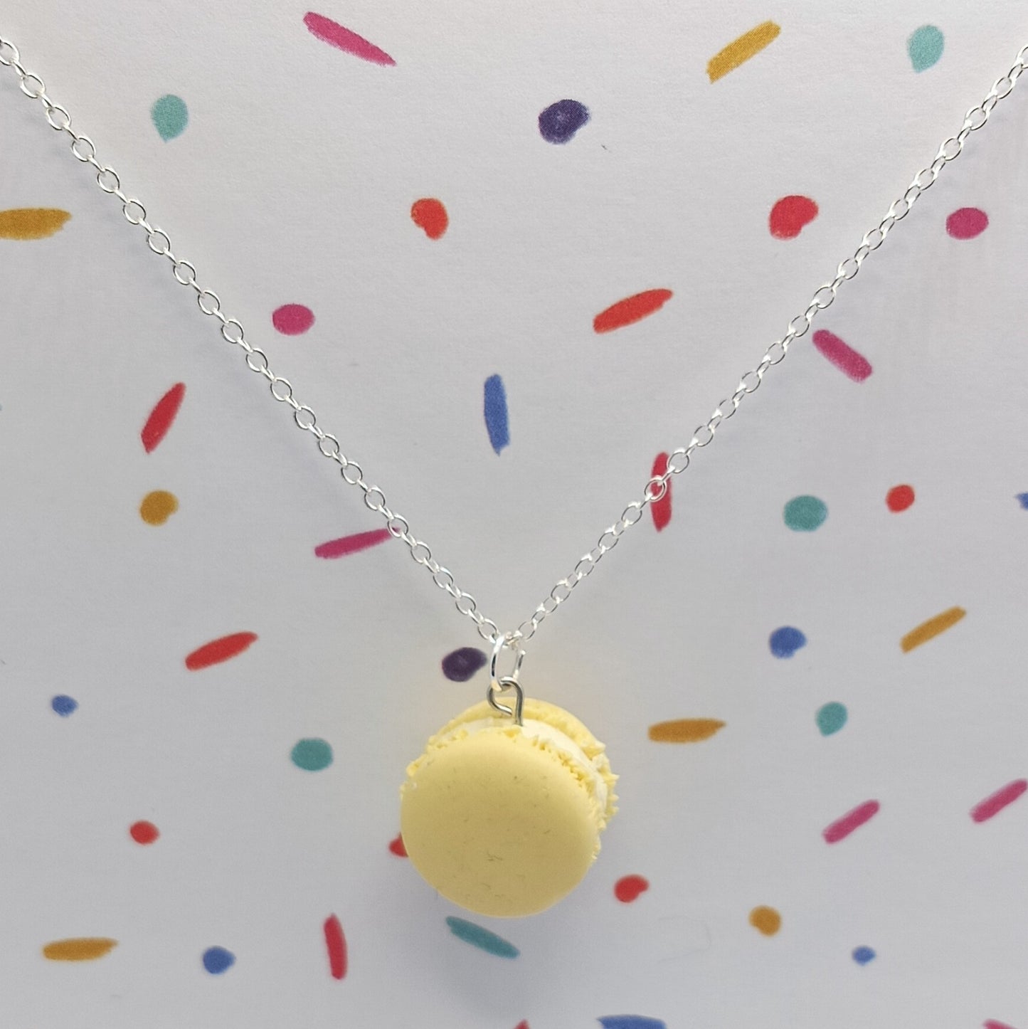 Lemon Macaron Pendant Necklace on silver chain and confetti background